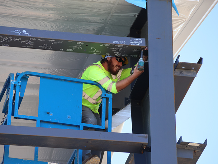 construction worker installing the final structural beam