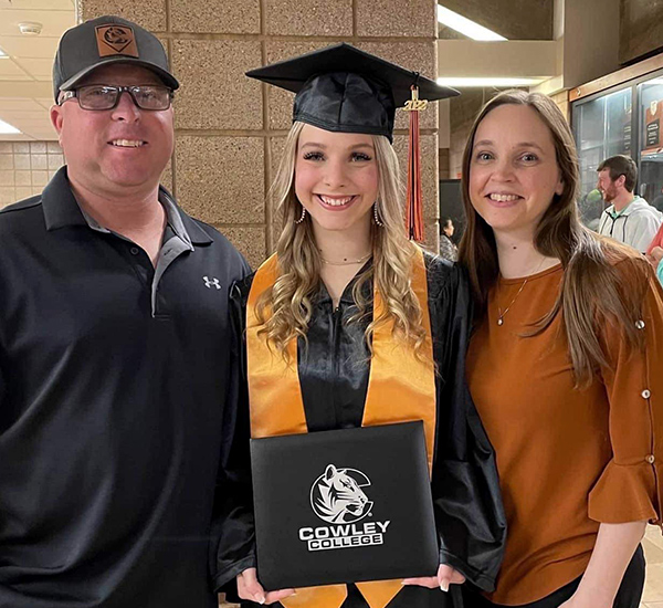 maddie at cowley college graduation with her parents