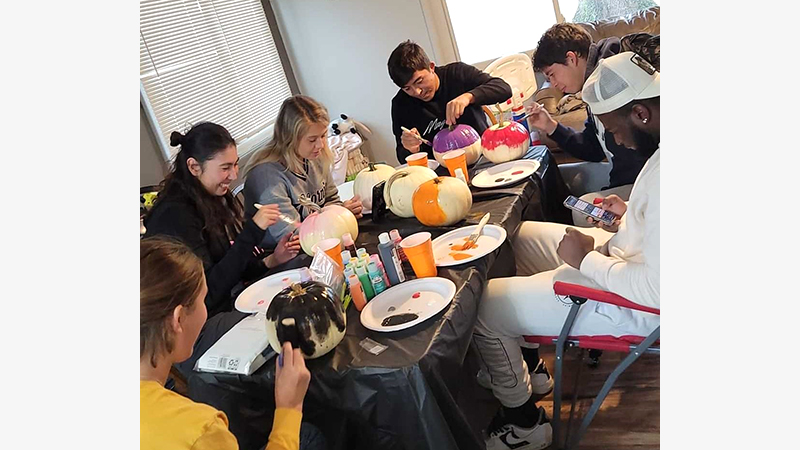 students painting pumpkins