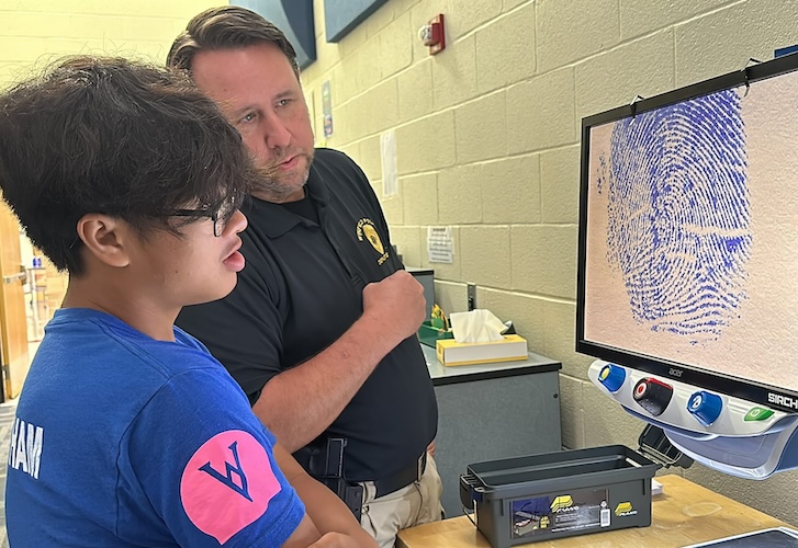 student and instructor looking at fingerprint technology
