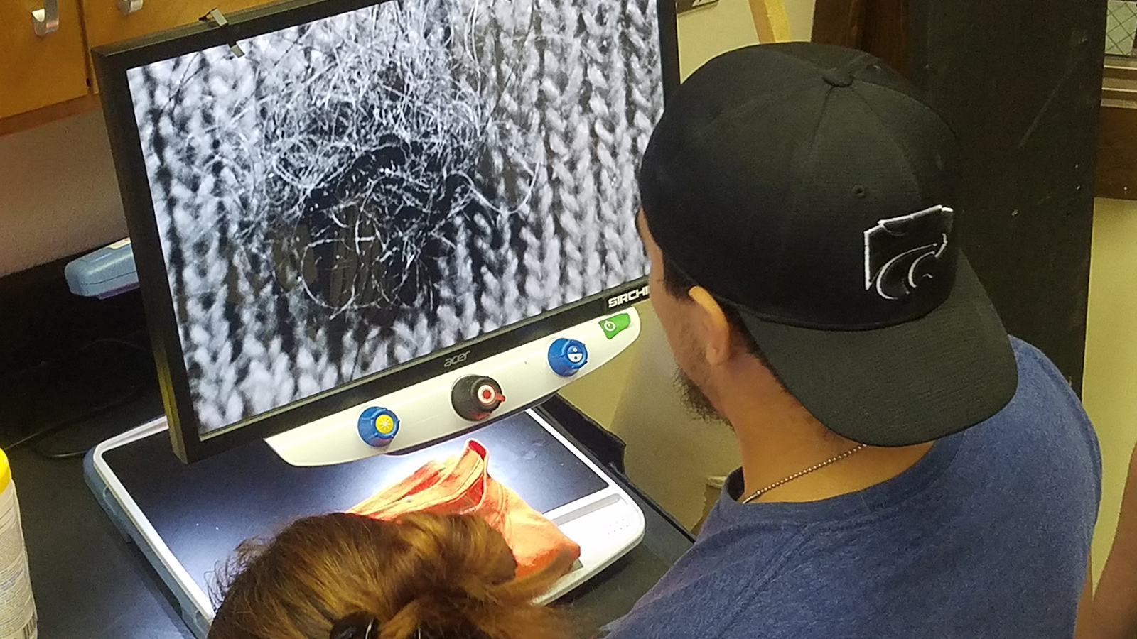 students examine hair sample at crime scene