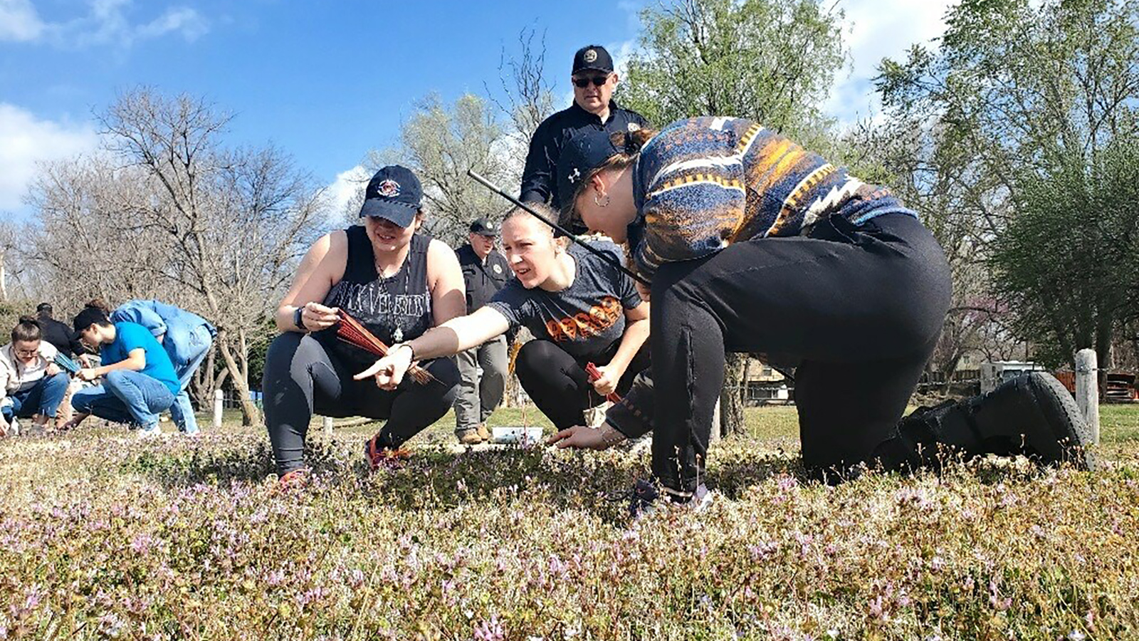 students examining an outdoor crime scene