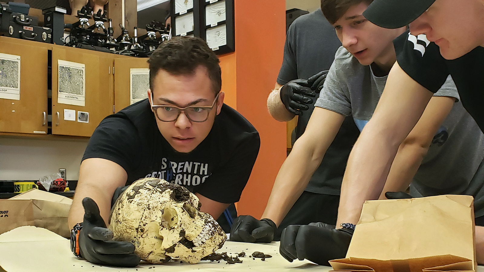 students examining a skull in lab