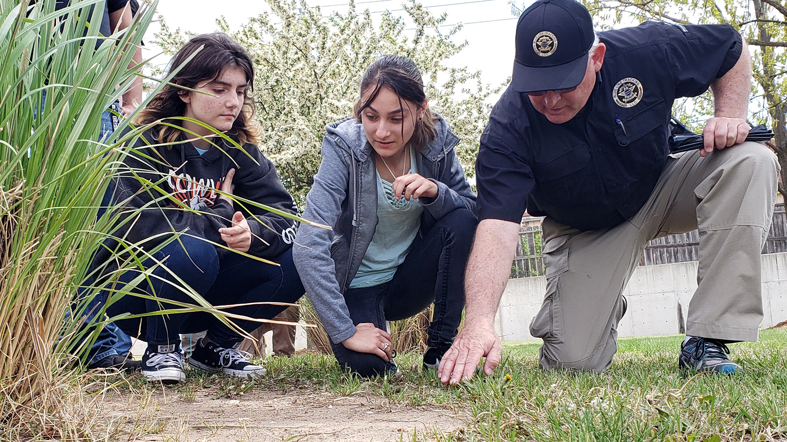 students examining foot prints at crime scene