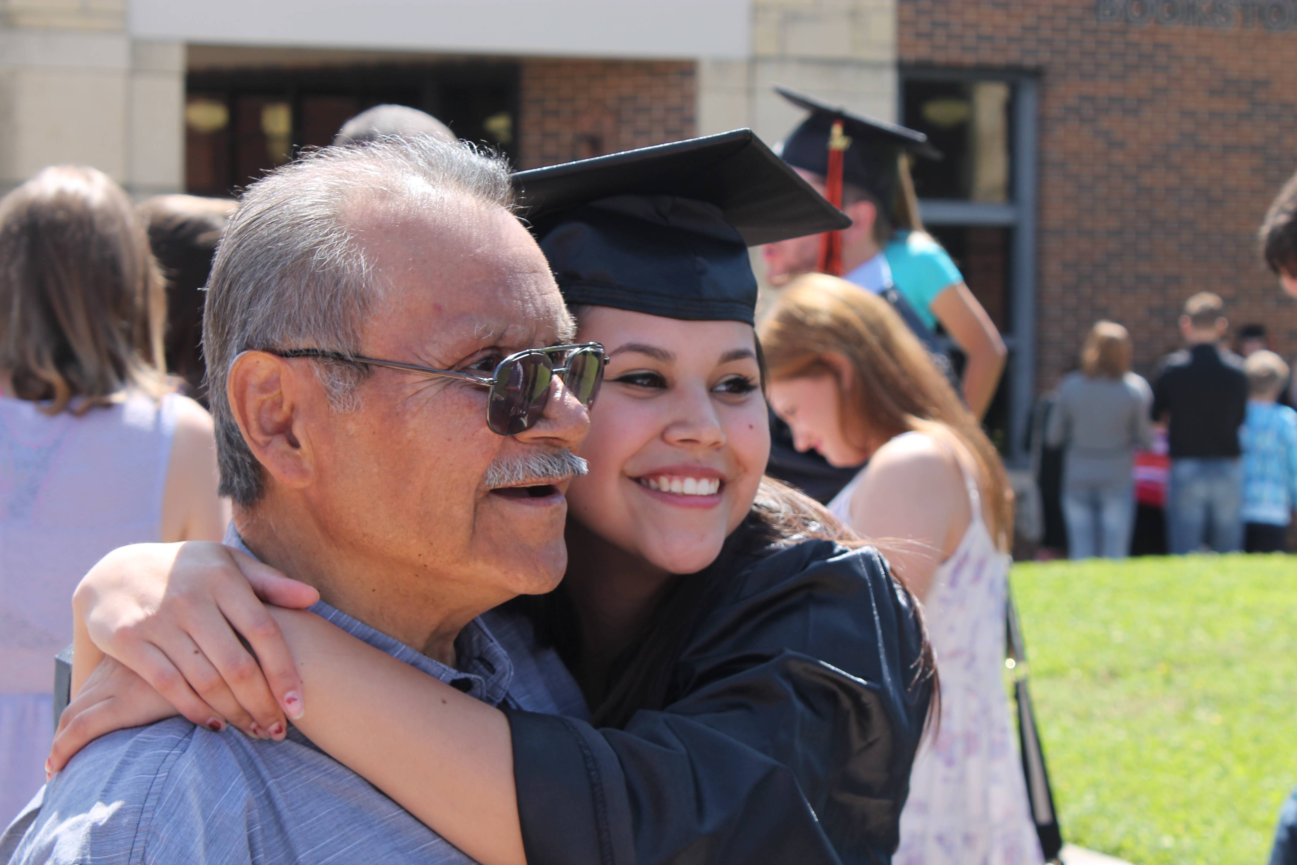 student at grduation hugging grandpa